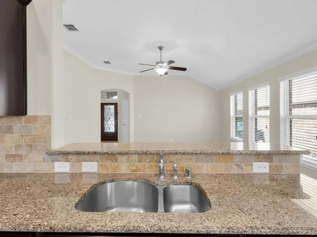a kitchen with a sink granite counter tops and a window