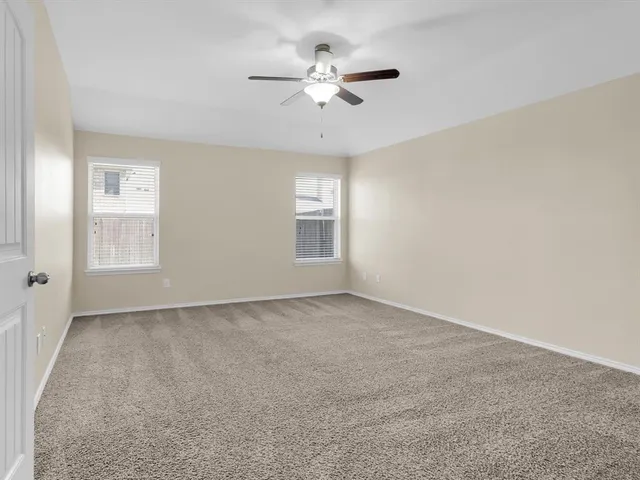 a view of an empty room with a chandelier fan
