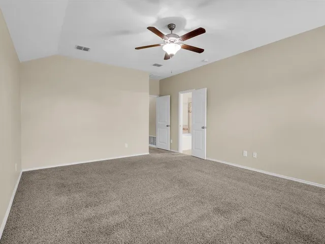 an empty room with closet and ceiling fan