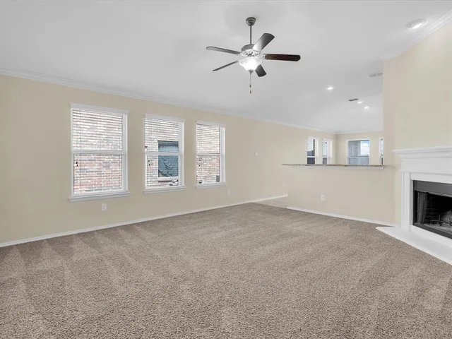 an empty room with windows and fireplace