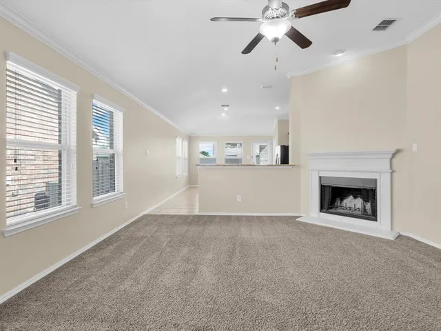 a view of an empty room with a fireplace and a window