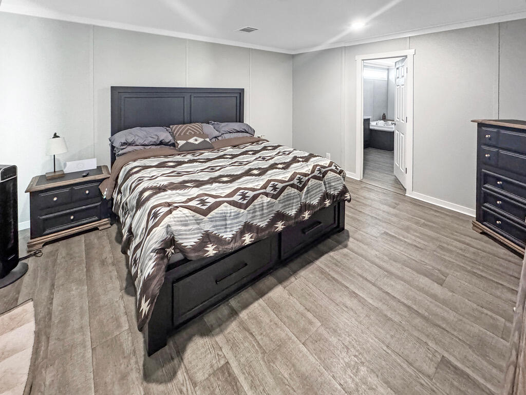 349 Private Road, Unit 243P Seminole, TX 79360 - Photo 15 of 24 a bedroom with a bed and wooden floor