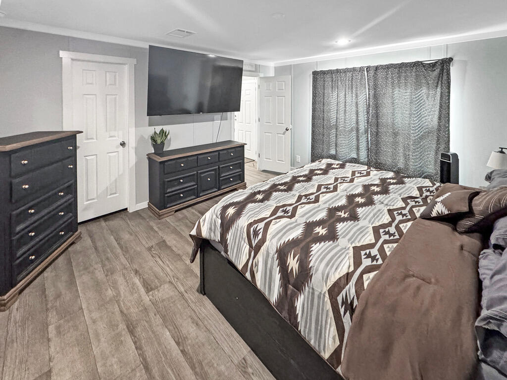 349 Private Road, Unit 243P Seminole, TX 79360 - Photo 16 of 24 a bedroom with a bed and a flat screen tv