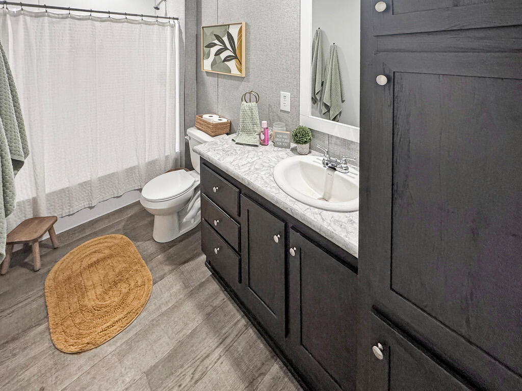 349 Private Road, Unit 243P Seminole, TX 79360 - Photo 18 of 24 a bathroom with a granite countertop sink toilet and a mirror