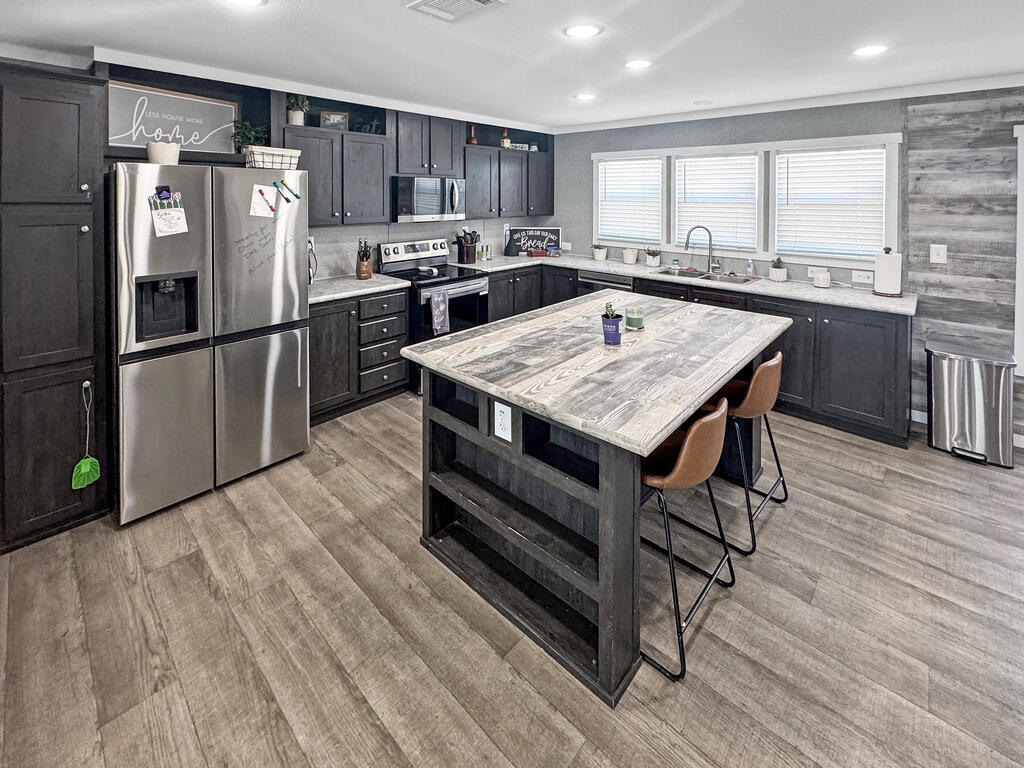 349 Private Road, Unit 243P Seminole, TX 79360 - Photo 3 of 24 a kitchen with stainless steel appliances a stove a refrigerator and a sink