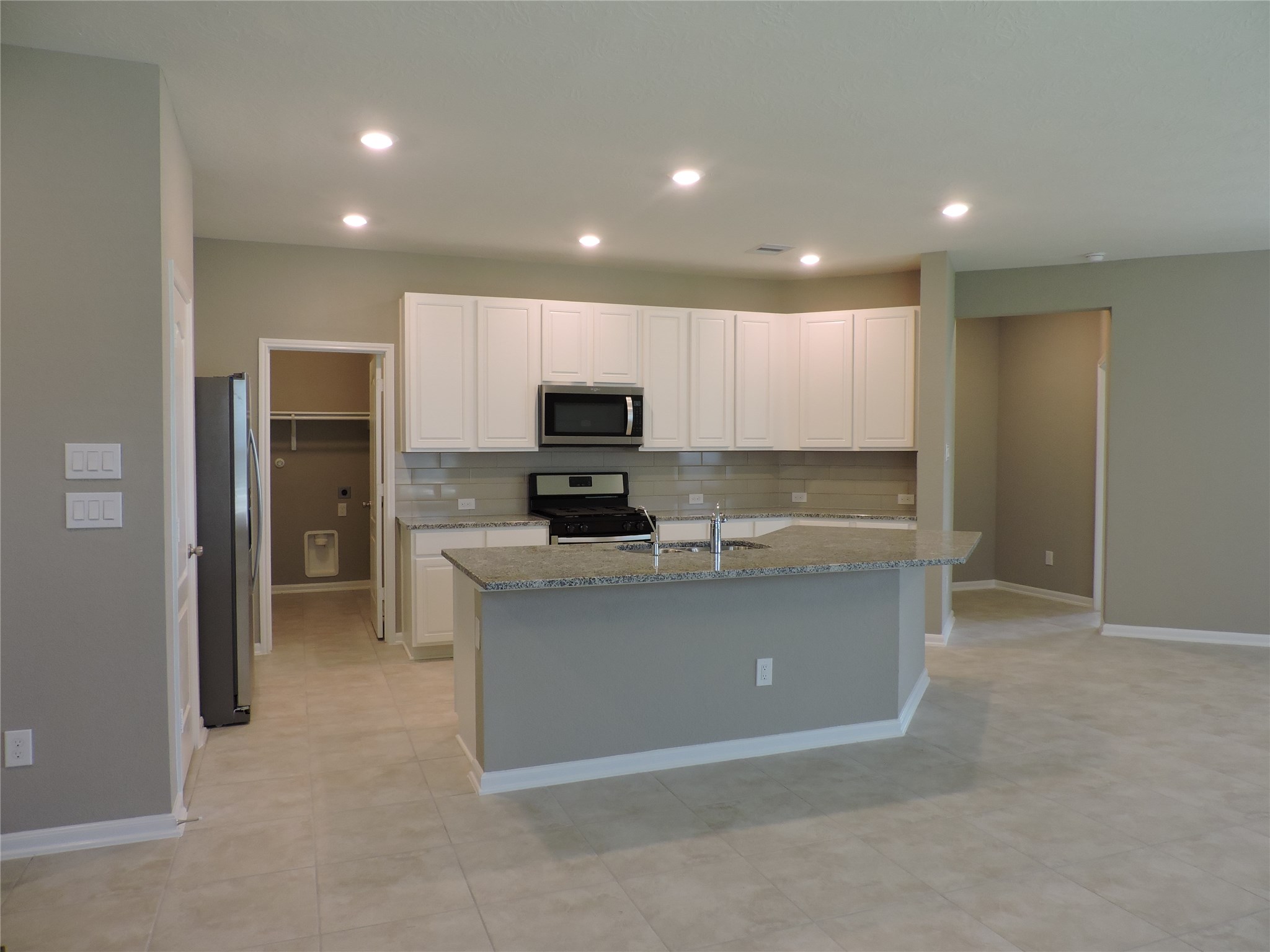 1102 Upton Court Conroe, TX 77304 - Photo 9 of 30 a view of kitchen with microwave stove refrigerator and cabinets