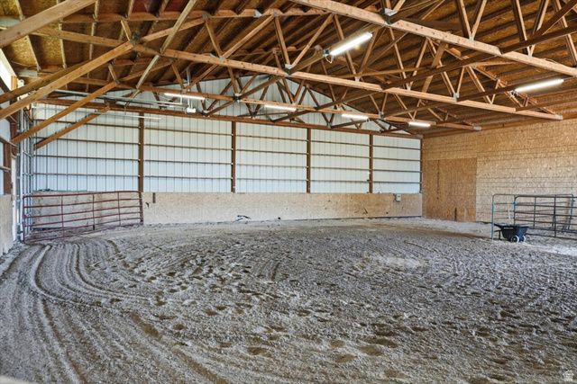 1634 West Arimo Road Arimo, ID 83214 - Photo 40 of 89 Spacious indoor riding arena featuring a sand base, exposed wood beam ceiling, metal siding, and perimeter fencing