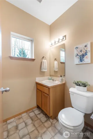 a bathroom with a toilet a sink and mirror