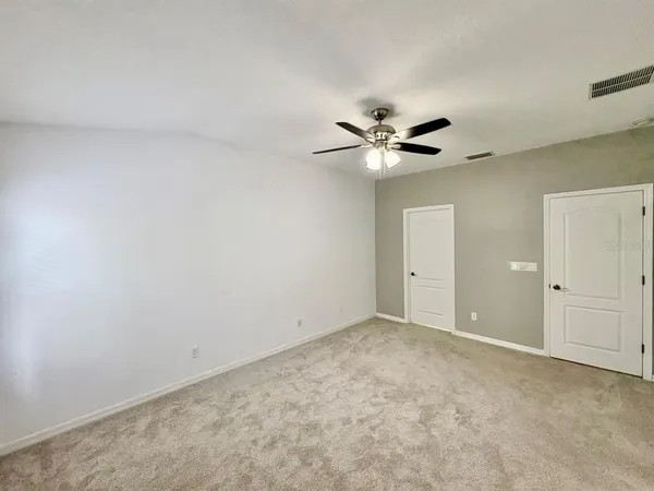 an empty room with a ceiling fan and a window