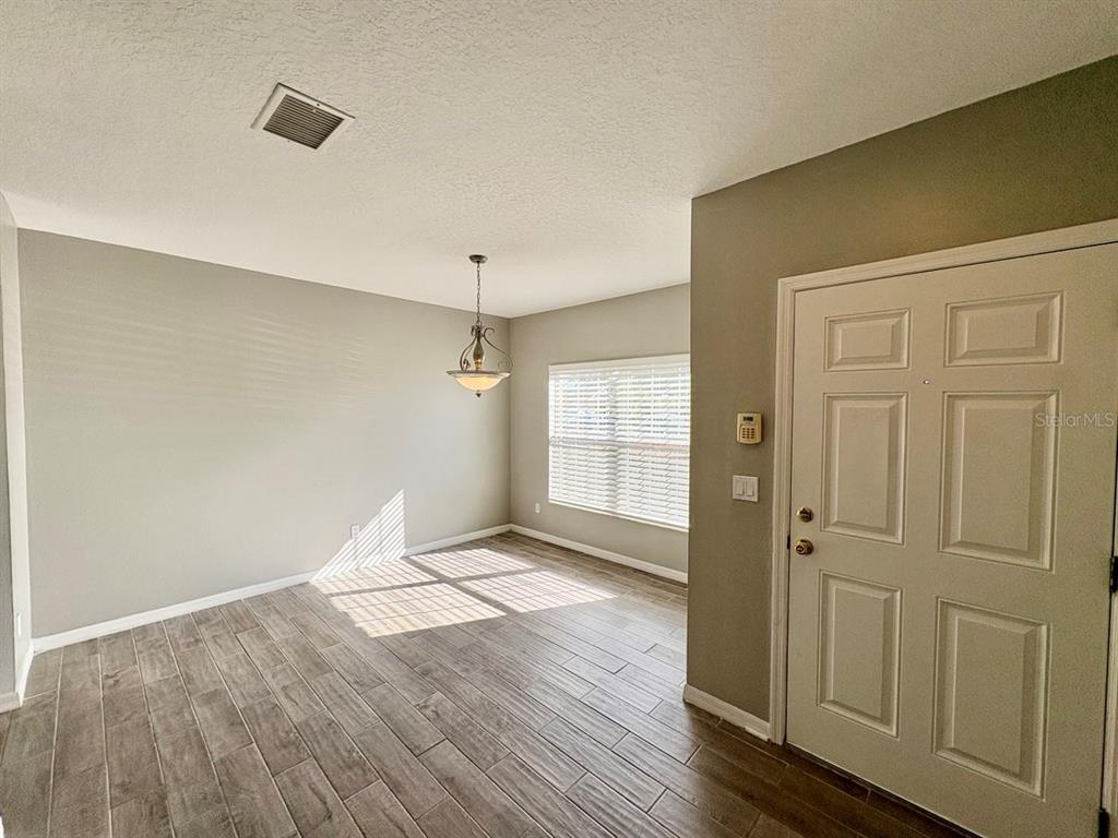 15619 Stable Run Drive Spring Hill, FL 34610 - Photo 4 of 28 an empty room with wooden floor and windows