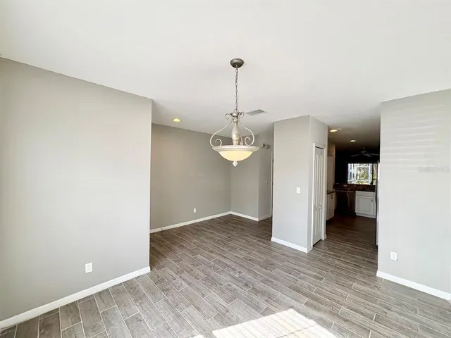 a view of a kitchen with wooden floor and a hallway
