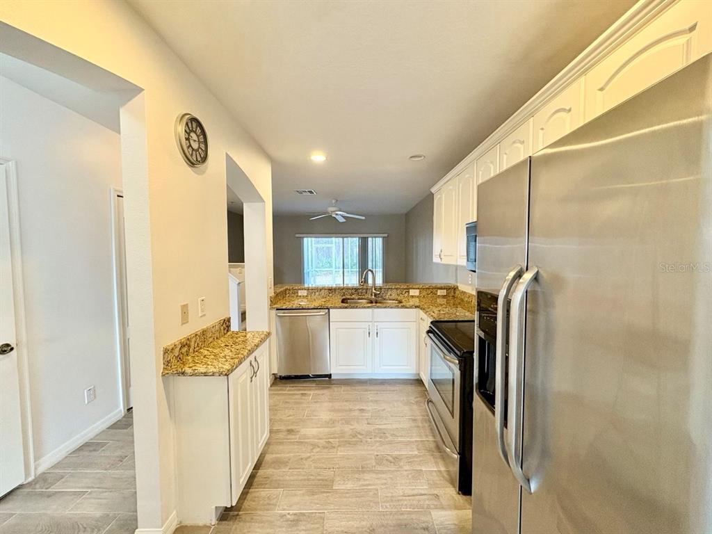15619 Stable Run Drive Spring Hill, FL 34610 - Photo 10 of 28 a kitchen with a refrigerator and a sink