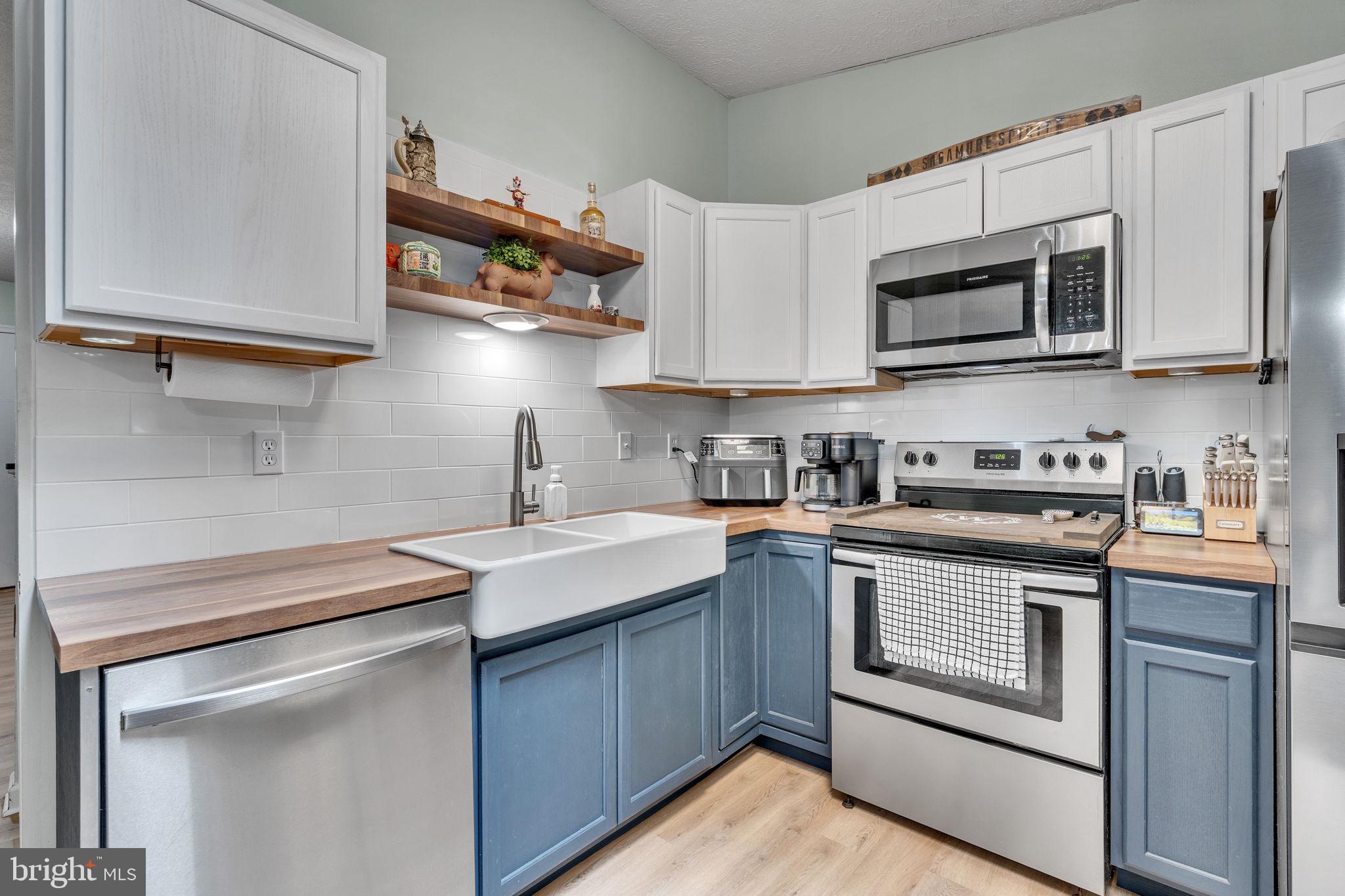 486 Round Up Road Lusby, MD 20657 - Photo 7 of 31 a kitchen with stainless steel appliances granite countertop a sink a stove and microwave