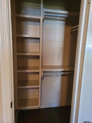 a view of walk in closet with empty racks