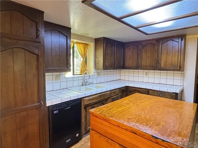 a view of an empty room with wooden floor and a ceiling fan