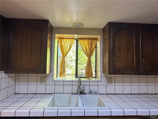 a bathroom with a granite countertop toilet sink and mirror