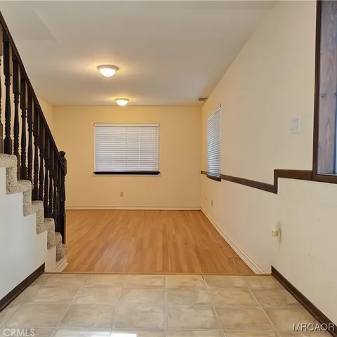 a view of an empty room with wooden floor and a fireplace