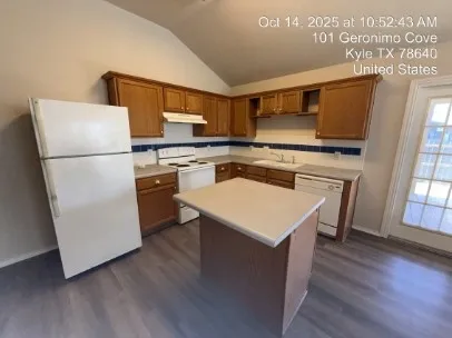 a kitchen with sink refrigerator and stove with wooden floor