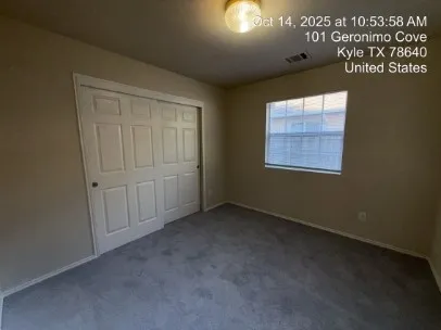 an empty room with a ceiling fan and a window