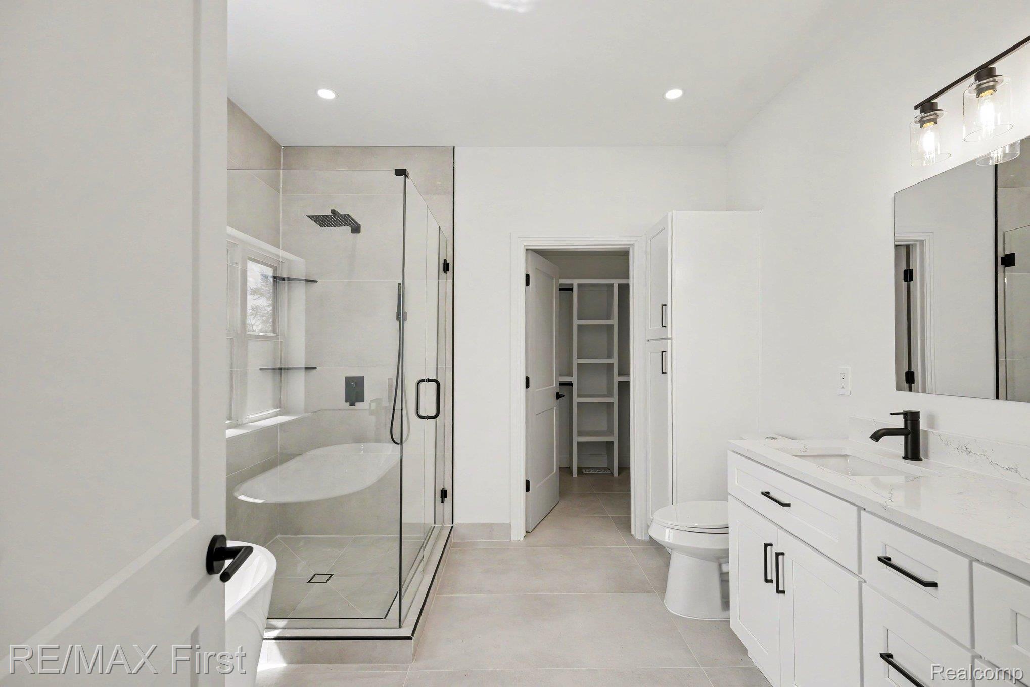 7424 Dyke Road Algonac, MI 48001 - Photo 22 of 31 Bathroom with vanity, a stall shower, a walk in closet, light tile patterned floors, and recessed lighting