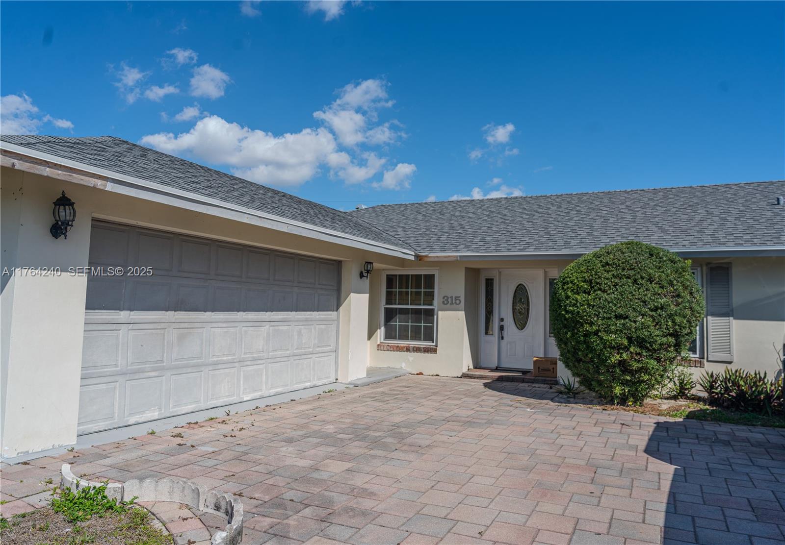 315 Southwest 12th Avenue Boynton Beach, FL 33435 - Photo 2 of 37 a front view of a house with a yard and garage