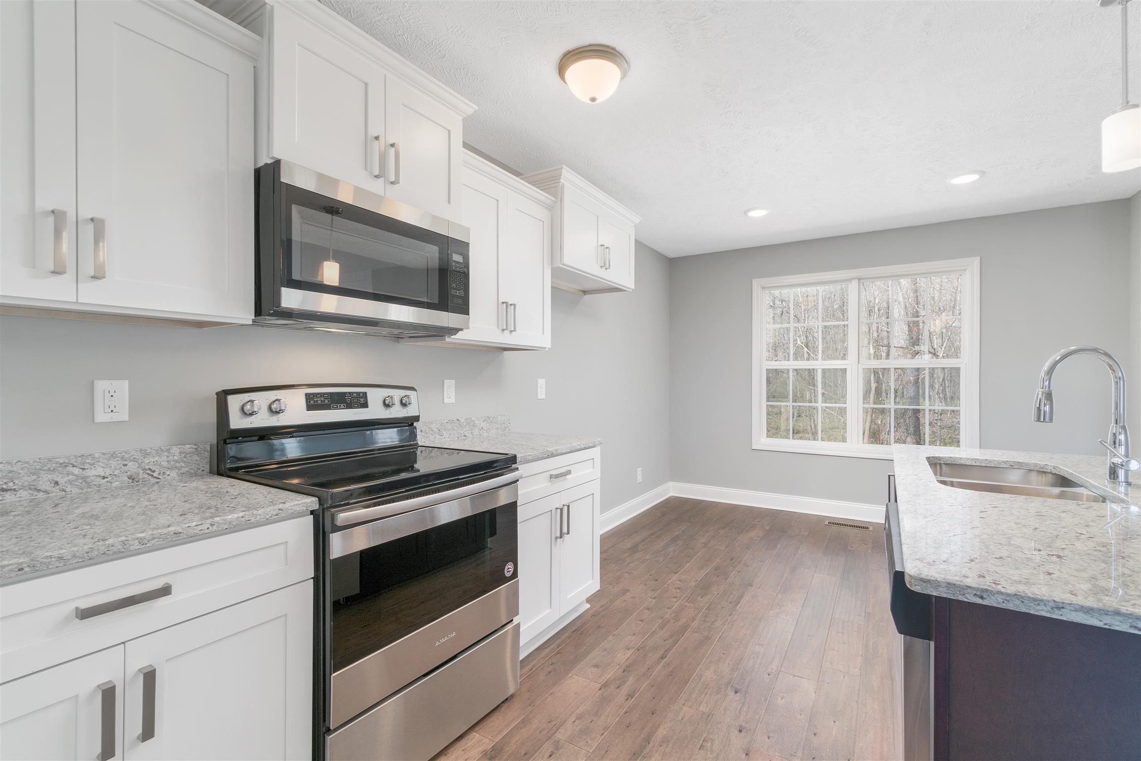 177 Fieldstone Lane Springfield, TN 37172 - Photo 6 of 27 a kitchen with stainless steel appliances granite countertop white cabinets a stove a sink and a microwave