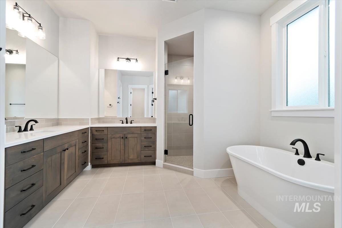 2147 East Blakehurst Avenue Kuna, ID 83634 - Photo 23 of 43 Full bath featuring a freestanding tub, vanity, light tile patterned floors, and a stall shower