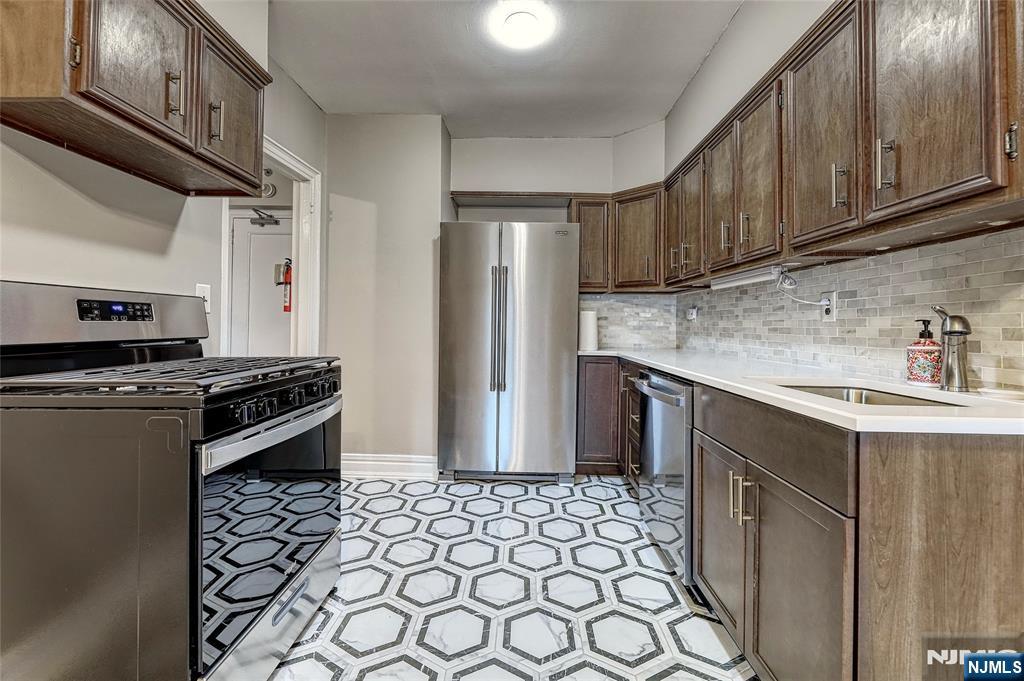 100 East Palisade Avenue, Unit D34 Englewood, NJ 07631 - Photo 4 of 12 a kitchen with stainless steel appliances a stove a sink and a refrigerator