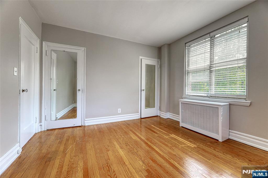 100 East Palisade Avenue, Unit D34 Englewood, NJ 07631 - Photo 7 of 12 a view of an empty room with wooden floor and a window