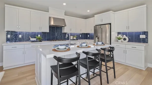a kitchen with a dining table chairs and white cabinets