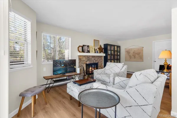 a living room with furniture a fireplace and a large window