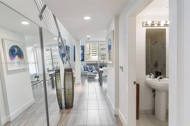 a view of a hallway with wooden floor and living room