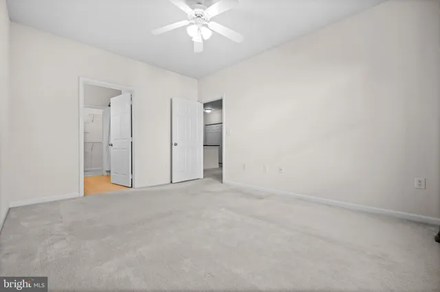 an empty room with fan and entrance