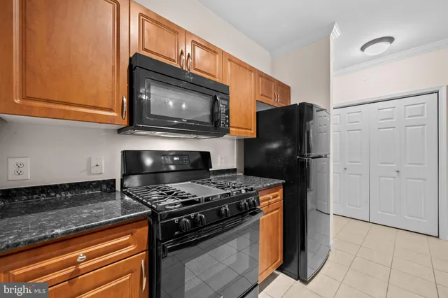 a kitchen with stainless steel appliances granite countertop a stove microwave and refrigerator