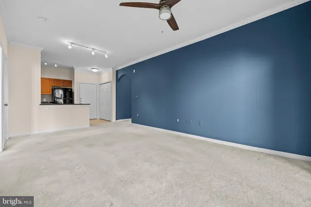 a view of a livingroom with a ceiling fan & kitchen floor