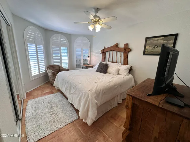 a bedroom with a bed a window and a chandelier