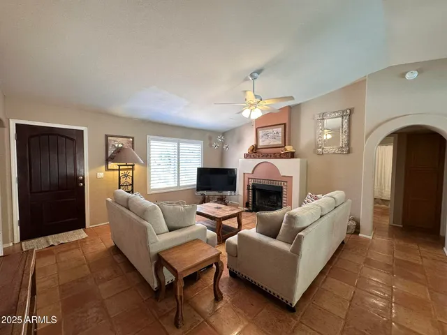a living room with furniture a fireplace and a window