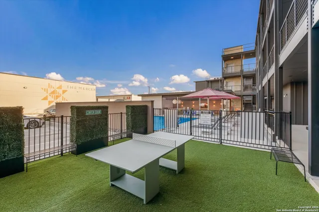 a view of a patio with a table and chairs under an umbrella