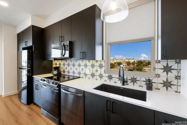 a kitchen with stainless steel appliances a sink a stove and a refrigerator