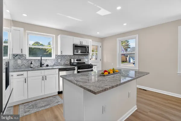 a kitchen with sink a window and chairs