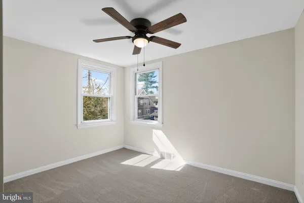an empty room with a window and a ceiling fan