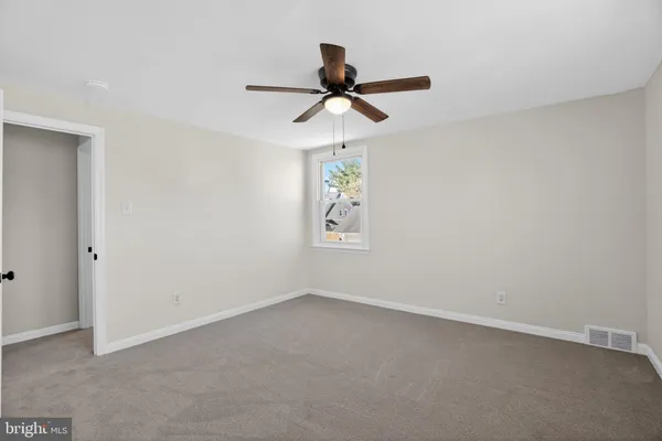 a view of room with a ceiling fan and a window