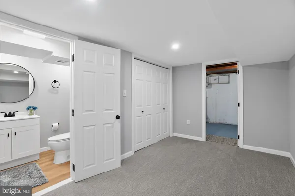 a spacious bathroom with a toilet a sink and a mirror