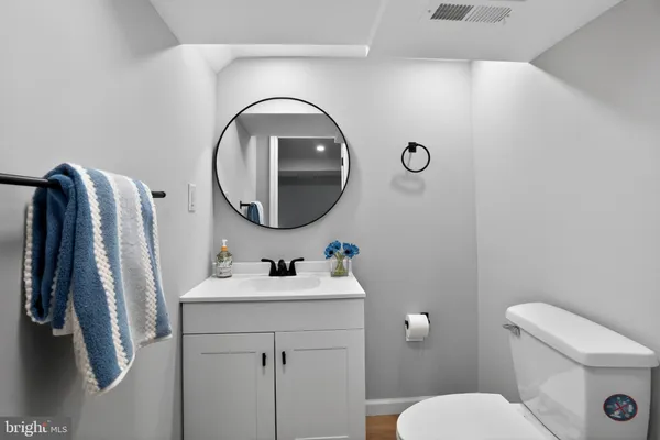 a bathroom with a sink a toilet and a mirror