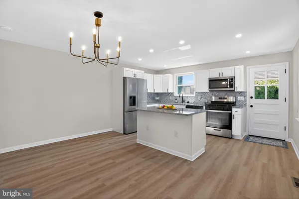a kitchen with granite countertop stainless steel appliances and wooden floor