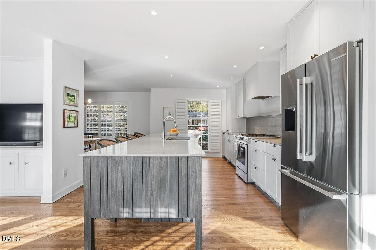 5904 Volant Drive Raleigh, NC 27609 - Photo 12 of 42 a large kitchen with stainless steel appliances kitchen island granite countertop a refrigerator and a stove top oven