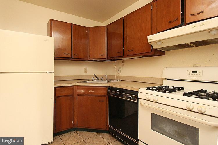 3122 Brinkley Road, Unit 303 Temple Hills, MD 20748 - Photo 10 of 30 a kitchen with stainless steel appliances granite countertop a stove a refrigerator and a sink