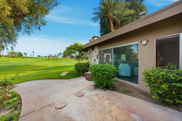 a front view of a house with swing and table and chairs