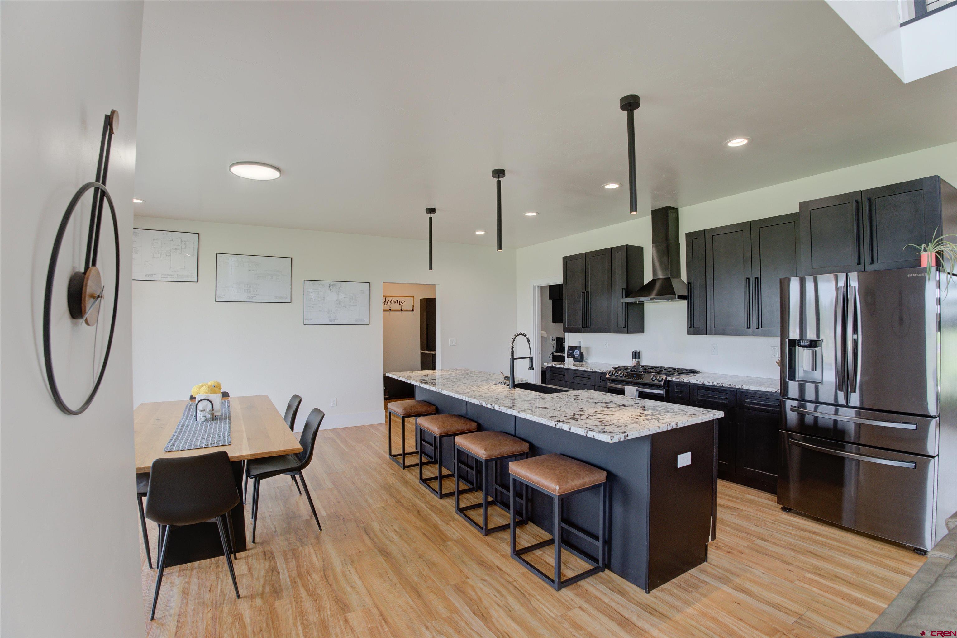 25320 Rd N.8 Loop Cortez, CO 81321 - Photo 5 of 40 a kitchen with stainless steel appliances granite countertop a stove refrigerator a sink dishwasher with a dining table and chairs