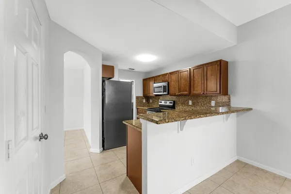 a kitchen with stainless steel appliances granite countertop a refrigerator a stove and a sink